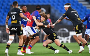 Hurricanes player Jordie Barrett is tackled hard during their Super Rugby match Moana Pasifika v Hurricanes. Eden Park, Auckland, New Zealand. Friday 25 March 2022. ©Copyright Photo: Andrew Cornaga / www.photosport.nz