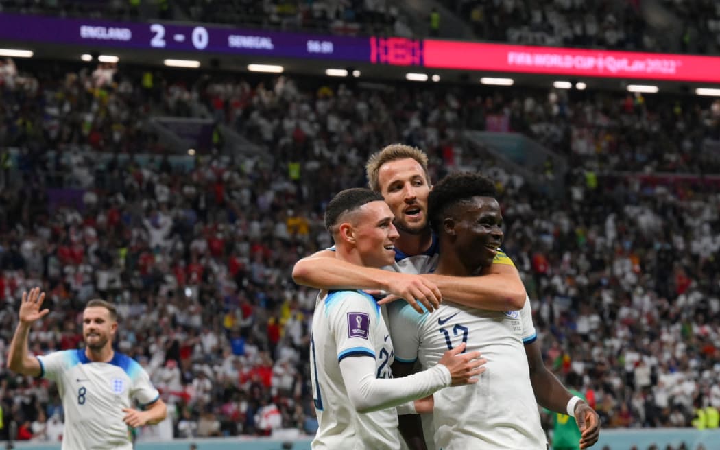 England's forward Bukayo Saka celebrates with Phil Foden (L) and Harry Kane after scoring his team's third goal during the Qatar 2022 World Cup round of 16 football match between England and Senegal at the Al-Bayt Stadium in Al Khor, north of Doha on 4 December, 2022.