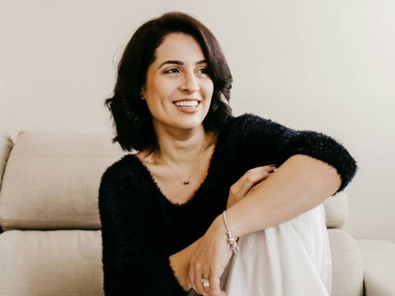A smiling woman in a black top.