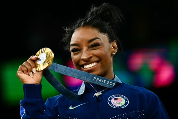 US' Simone Biles poses with her gold medal during the podium ceremony after the artistic gymnastics women's all around final during the Paris 2024 Olympic Games at the Bercy Arena in Paris, on August 1, 2024. (Photo by Loic VENANCE / AFP)