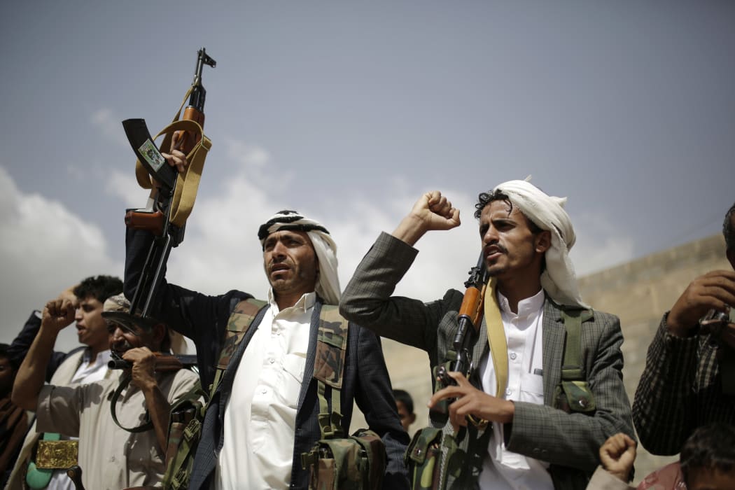 Houthi rebel fighters hold their weapons and shout slogans during a gathering aimed at mobilizing more fighters before heading to battlefronts.