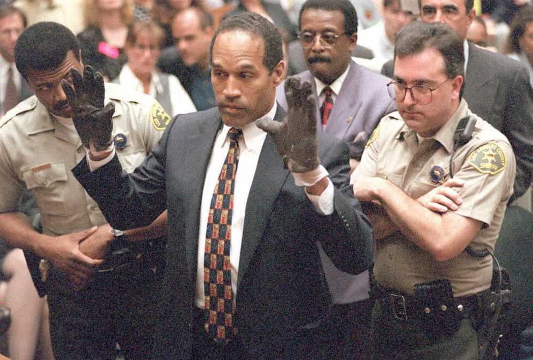 Double murder defendant OJ Simpson holds up his hands for the jury after he tried on the bloody gloves found at the Bundy murder scene and at his Rockingham residence during the OJ Simpson murder trial 15 June 1995.