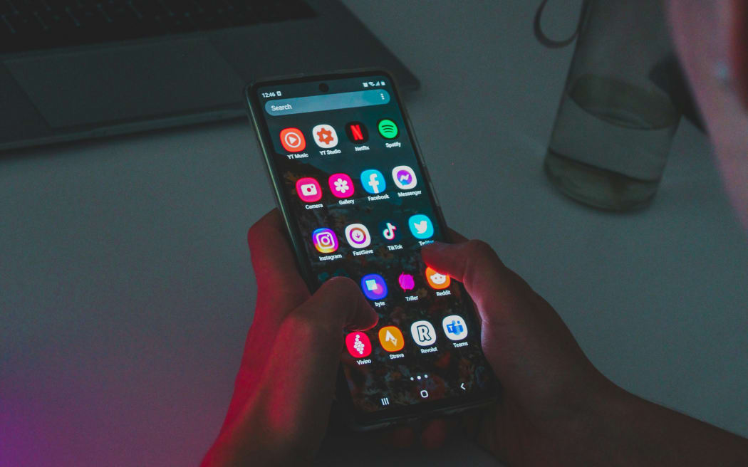 A person using a mobile phone at a desk.
