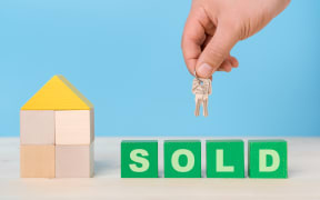 The word SOLD on green wooden cubes. The concept of selling a house or renting a home