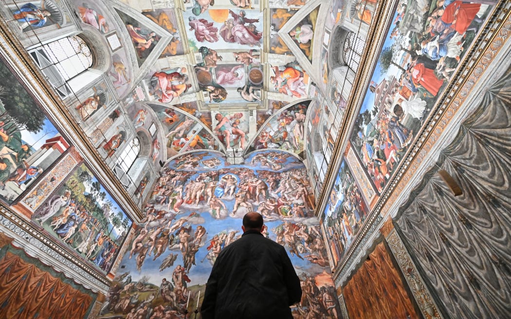A man visits the Sistine Chapel on the reopening day of the Vatican museum on February 1, 2021 in Vatican City, as the city-state eases its closure aimed at curbing the spread of the COVID-19 infection, caused by the new coronavirus. (Photo by Andreas SOLARO / AFP)