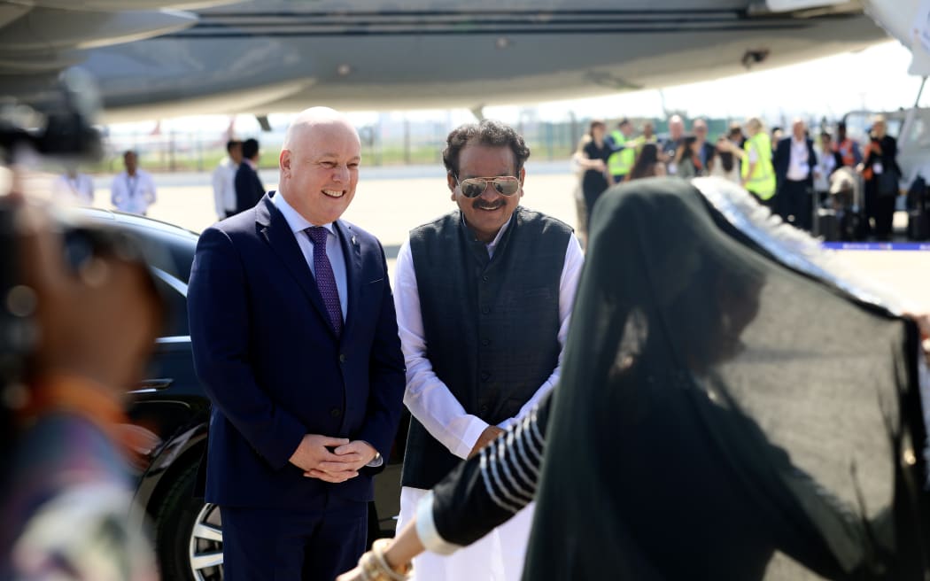 Christopher Luxon stands next to Indian government minister Prof. S.P Singh Baghel while they watch a dance performance at Palam Air Force Station in New Delhi