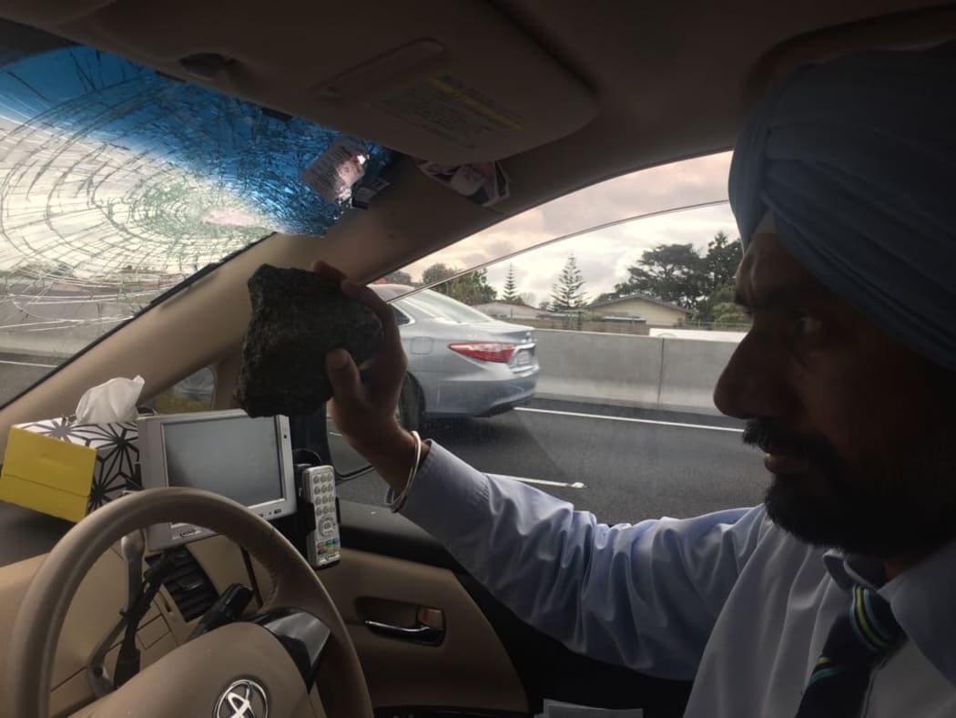 Balkar Singh holds the rock that was thrown from a motorway overbridge into his car.