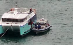 The East by West ferry apparently lost power while transporting passengers. Pictured, police help tow the boat back to Queens Wharf.