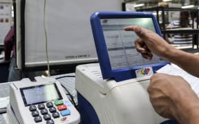 A worker tests the voting machines that will be used in the upcoming presidential elections, during an audit in Caracas on May 14, 2018.