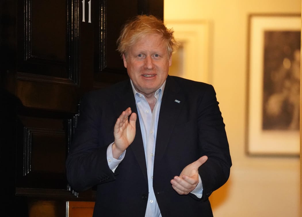 Boris Johnson participates in a national 'clap for carers' in the doorway of 10 Downing Street on April 2, 2020.
