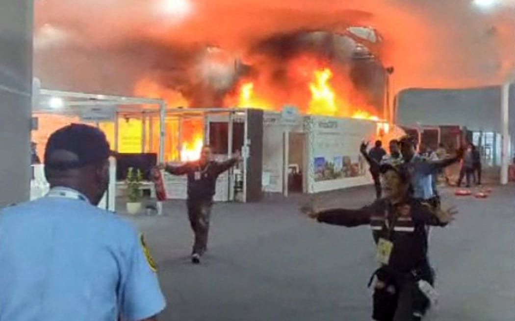 This screen grab taken from AFPTV video footage shows emergency crews battling a fire that broke out at a pavilion inside the venue of the COP30 UN Climate Change Conference in Belem, Para state, Brazil, on November 20, 2025. A fire erupted at a pavilion inside the venue of the UN's climate talks in Brazil on Thursday, prompting panicked delegates to run for the exits, AFP journalists said. Emergency crews rushed to try to put out the blaze as smoke engulfed the corridor. (Photo by AFPTV / AFP)