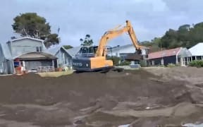 A still from a video taken by a local resident shows a digger at work on the beach at Church Bay, northeast of Whangārei.