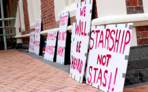 Signs outside the Court in Auckland on 30 November 2022 during a hearing on parents who wanted their baby to have blood transfusions only from someone who had not been vaccinated against Covid-19.