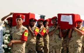 Coffins are carried in the funeral for 30 solders killed in the latest outbreak of violence in the Sinai Peninsula.