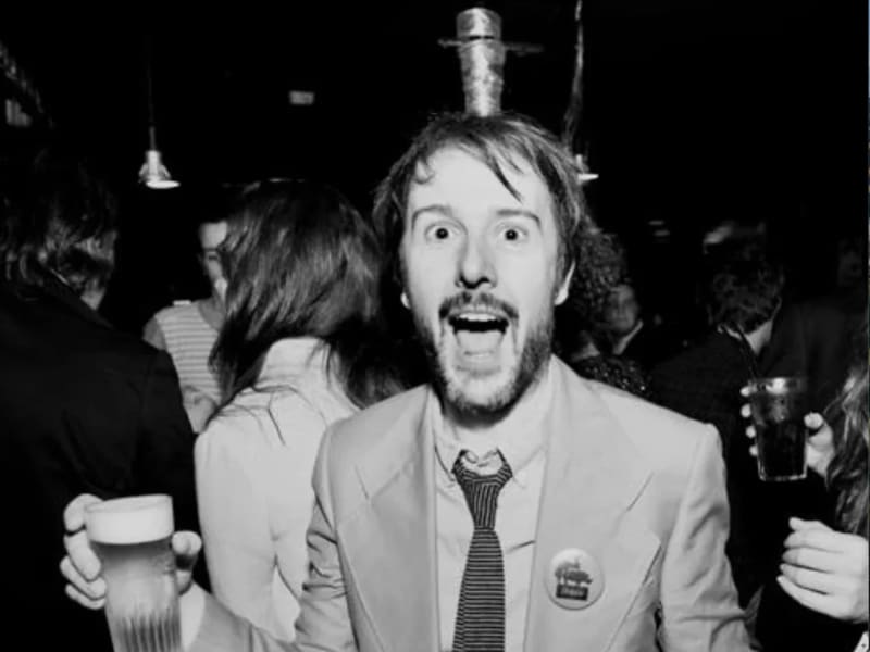 Stefaan Van Leuven is a happy-looking man in a suit holding a beer.