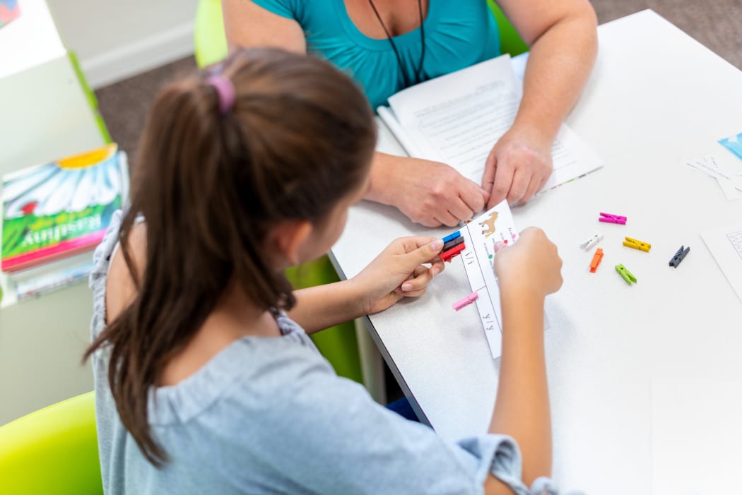 Teacher working with a teenage girl with learning difficulties.