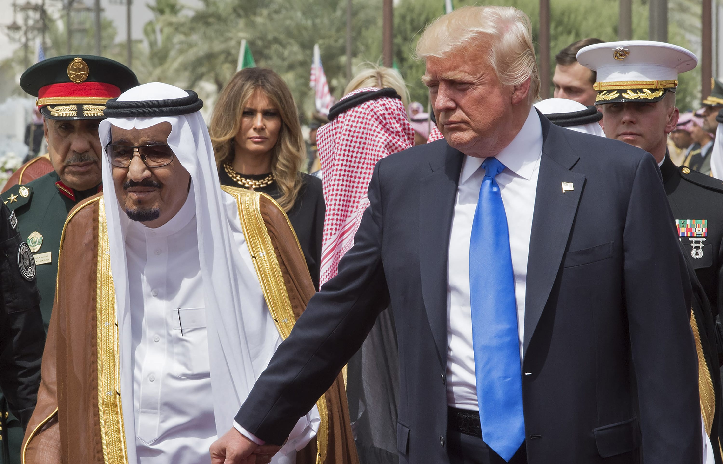 US President Donald Trump holding the hand of Saudi Arabia's King Salman bin Abdulaziz al-Saud (L), as First Lady Melania Trump  looks on, as they arrive for a welcoming ceremony at the Saudi Royal Court in Riyadh on 20 May, 2017.