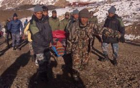 An injured survivor of the snowstorm in the Himalayas is rescued.