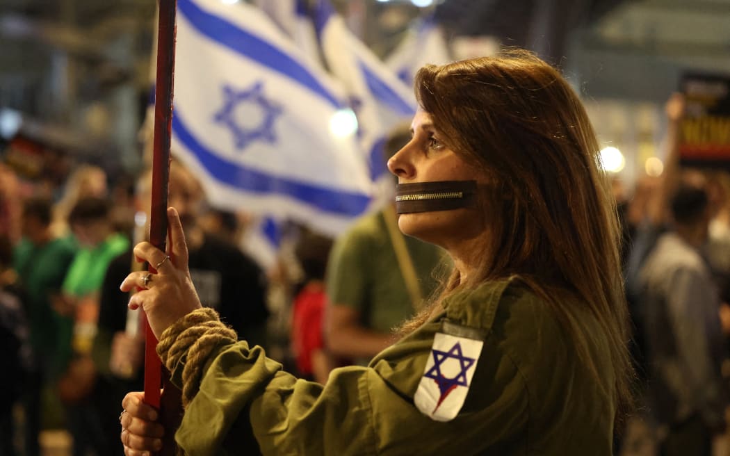 A Protester carries a placard during a gathering by relatives of Israeli hostages held in Gaza since the October 7 attacks by Hamas militants, in front of the Defense Ministry in the Israeli coastal city of Tel Aviv, on March 30, 2024, amid the ongoing conflict in the Gaza Strip between Israel and the Palestinian militant Hamas movement. (Photo by JACK GUEZ / AFP)