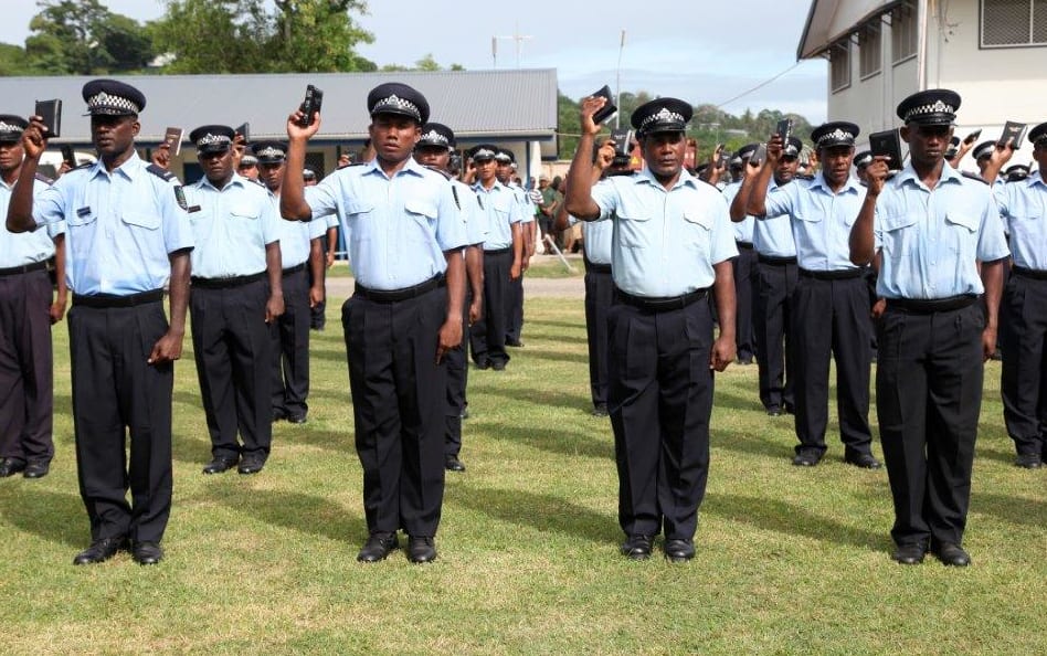 RSIPF officers raise the bible in their right hands as they re-affirm their oath of allegiance in preparation for rearmament.