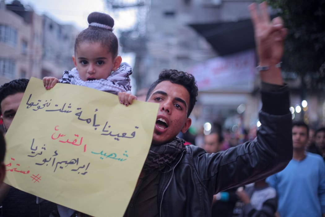 A Palestinian demonstrator holds a sign at a rally in Jabalia refugee camp in northern Gaza Strip on Wednesday.