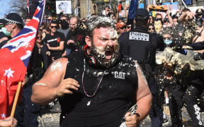 A protester reacts from pepper spray used by police during an anti-lockdown rally in Melbourne today.