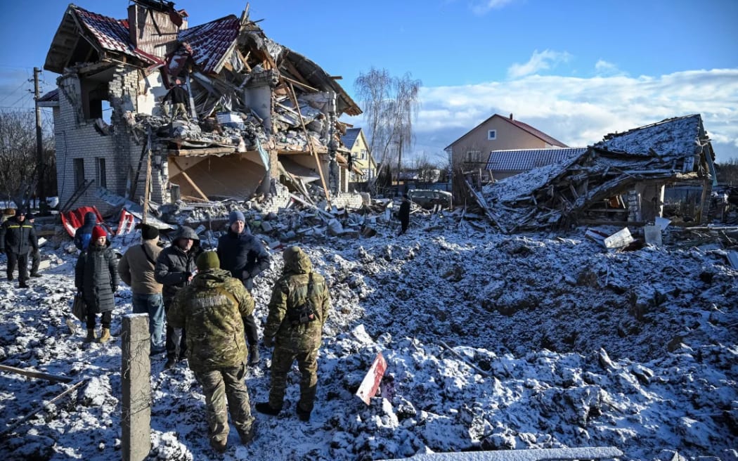 Residents and bomb squad members stand in front of a house destroyed by a Russian missile strike on Saturday.