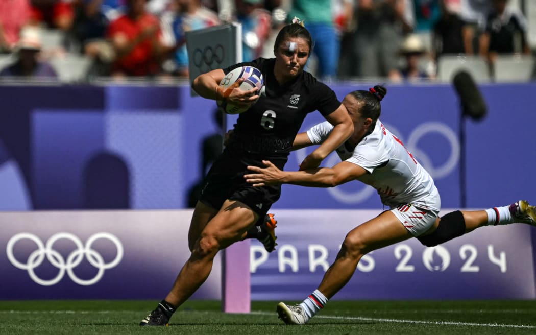 New Zealand's Michaela Blyde runs to score a try as tackled by US' Lauren Doyle (R) during the women's semi-final rugby sevens match between New Zealand and USA during the Paris 2024 Olympic Games at the Stade de France in Saint-Denis on July 30, 2024. (Photo by CARL DE SOUZA / AFP)