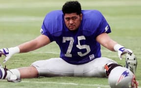 Pio Sagapolutele stretches before an NFL  game in 1997.
