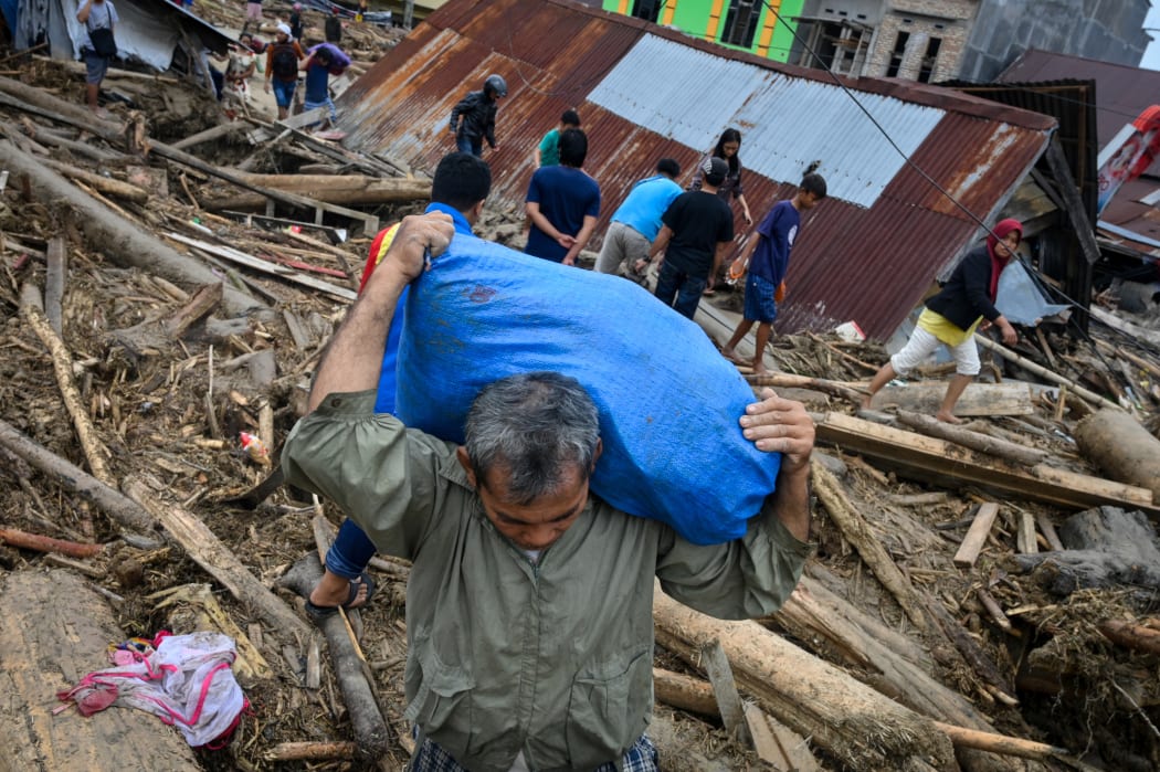 Villagers search for their belongings from their homes before moving to evacuation camps following flash floods in North Luwu regency in Indonesia's South Sulawesi on July 15, 2020.