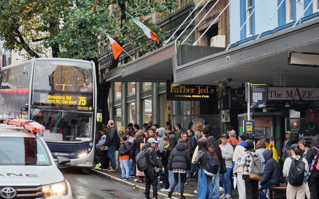 People queued up waiting for a bus to arrive on Wellesley Street on 9 May, 2023.