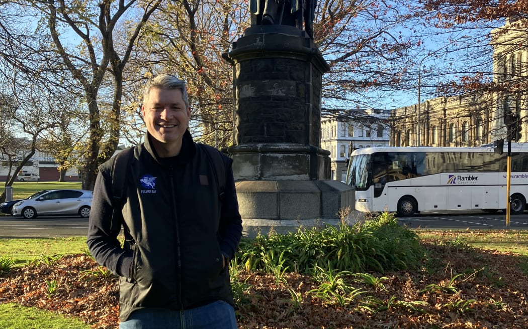 Jesse Mulligan in front of the statue of Dr. Donald McNaughton Stuart, Dunedin.