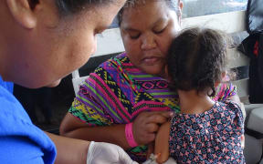 A Majuro hospital nurse provides a measles vaccine during a community outreach vaccine programme.