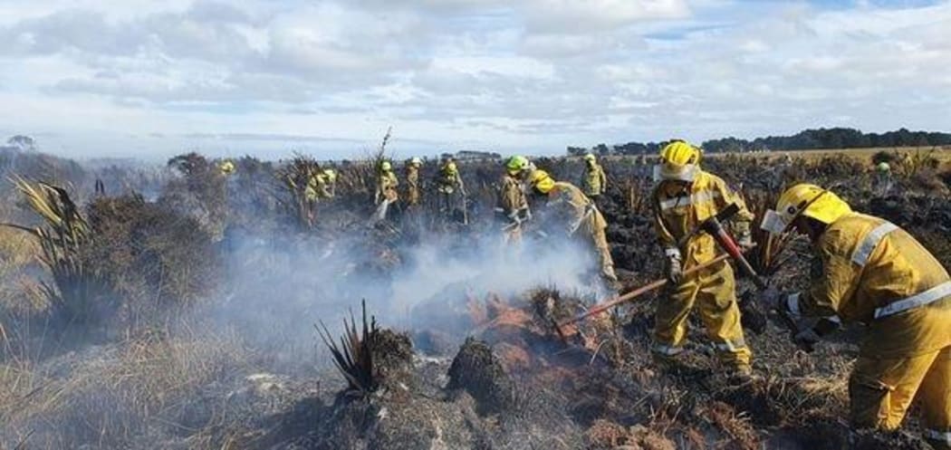 Firefighters working on putting out the Awarua Bay fire.
