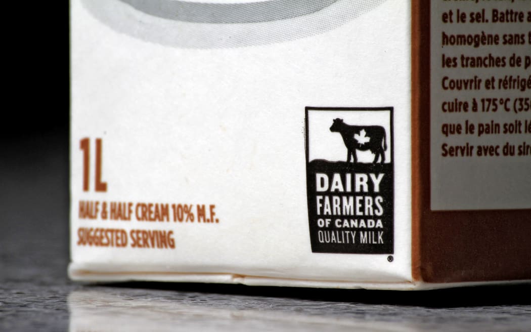 A Dairy Farmers of Canada Quality Milk label is shown in Brampton, Canada, on February 3, 2025. Sweeping tariffs imposed by US President Donald Trump on many Canadian products, including dairy, force many Canadians to check labels for Canadian-made or produced products as a response to potential higher grocery costs.