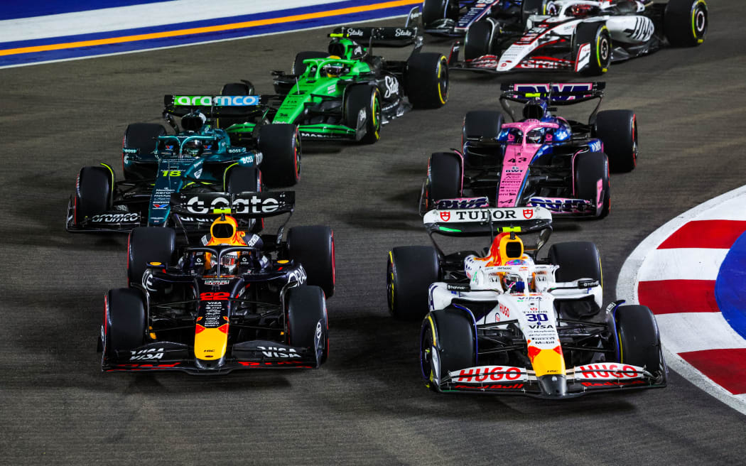Liam Lawson (R), races in the Singapore Grand Prix, with Yuki Tsunoda racing on his outside, 6 October, 2025. (Photo by Florent Gooden / DPPI via AFP)