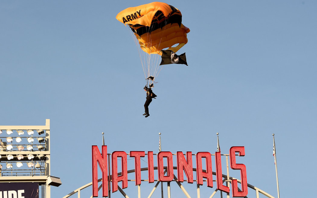 WASHINGTON, DC - APRIL 20: A member of the US Army Parachute Team The Golden Knights lands at Nationals Park before the game between the Washington Nationals and the Arizona Diamondbacks on April 20, 2022 in Washington, DC.