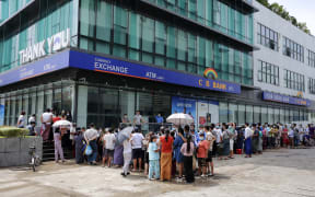 People queue for a long time to withdraw money from ATM machines of CB Bank at the downtown area in Yangon on April 30, 2021 following the Myanmar military coup in early February.