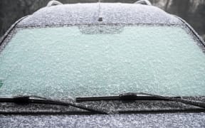 frozen windshield of a car with ice and snow, concept of traffic risks in winter, copy space, selected focus