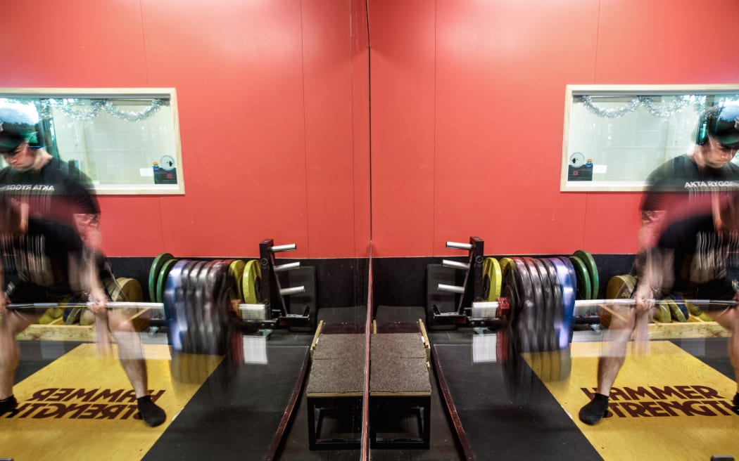 Artistic shot of Chris Kennedy lifting weights