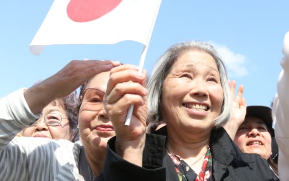 A woman waves Japan's national flag during Japan's new Emperor Naruhito's public appearance at the Imperial Palace in Tokyo on May 4, 2019.