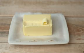 A block of butter on a white dish.