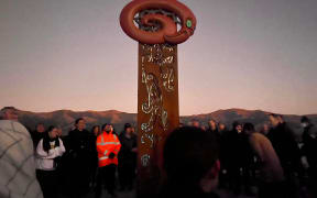 A pou is unveiled at dawn on Banks Peninsula as part of the first stage of Takapūneke Reserve in Akaroa.