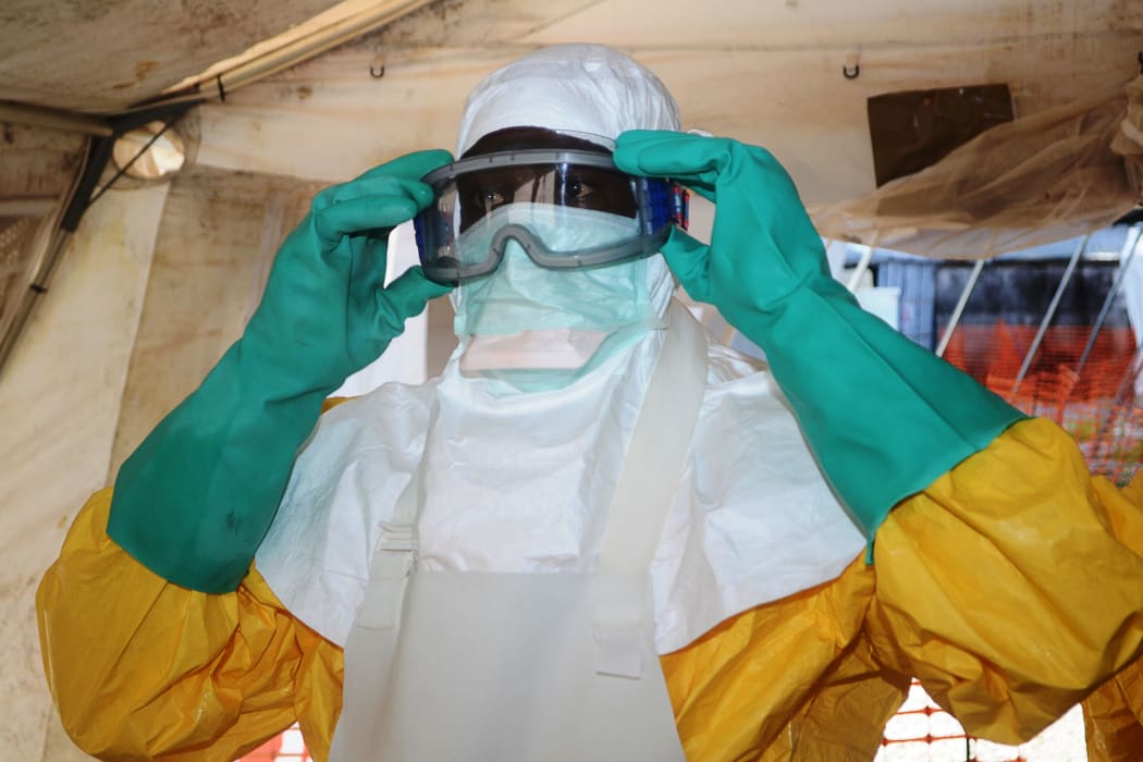 A member of Doctors Without Borders dons protective gear.
