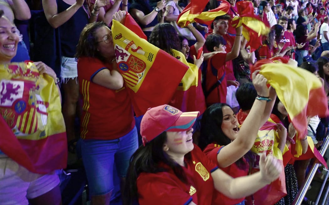Spain fans celebrate their team's win as they watch a live broadcast of the Women's World Cup final football match between Spain and England, at the Palacio de los Deportes pavilion in Madrid on August 20, 2023. (Photo by JAVIER SORIANO / AFP)