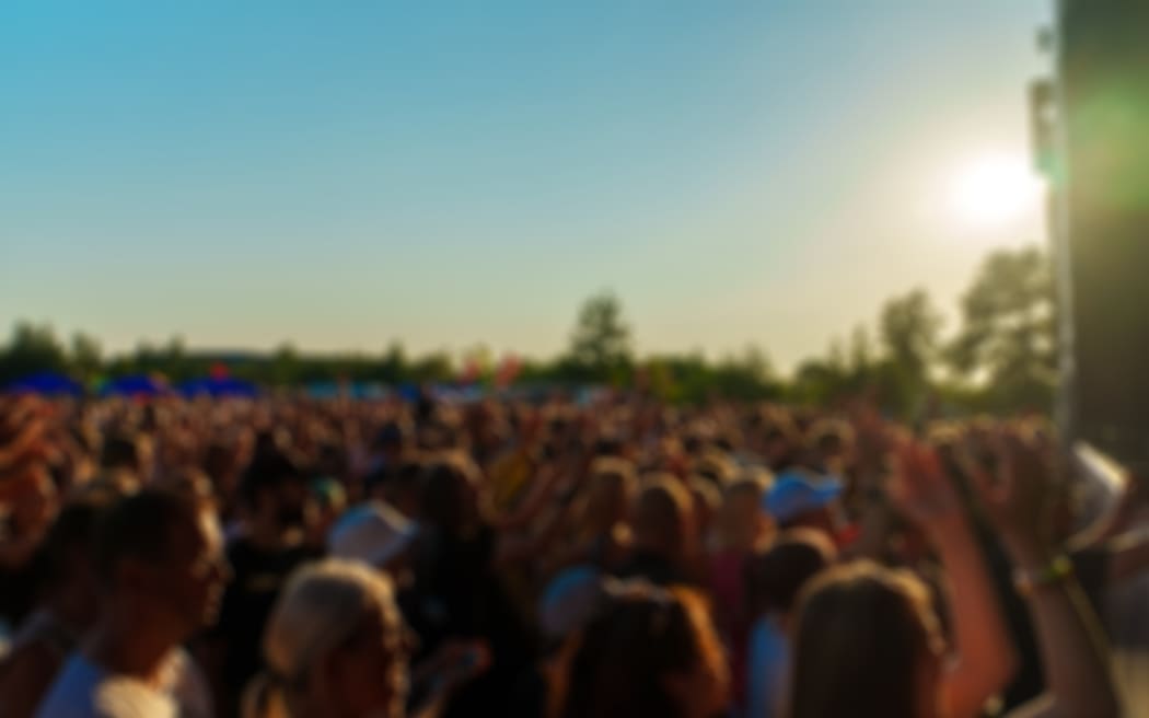 People watching music concert on large stage. Blurred image. Festival