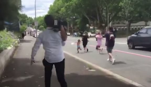 Media pursue an "unruly tourist" outside the court in Hamilton.