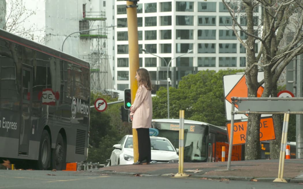 RNZ reporter Louise Ternouth crosses the road in Auckland's CBD.