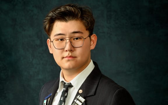 Pinehurst School student Kevin Guo in his school uniform, wearing glasses, for a portrait.