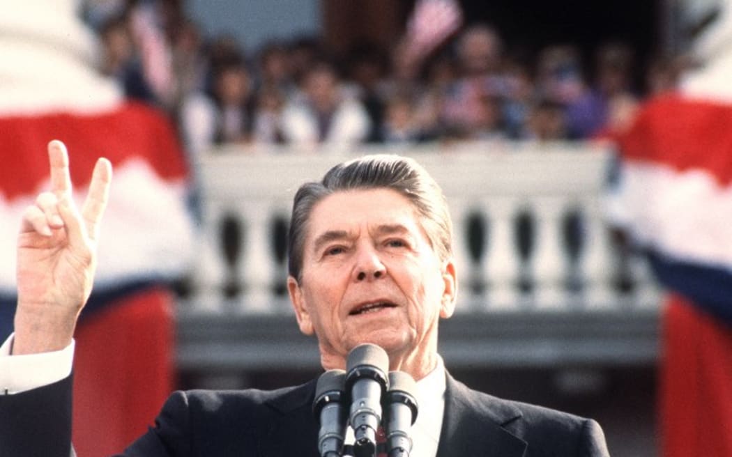 US President and Republican presidential candidate Ronald Reagan makes the V sign as he addresses supporters at an electoral meeting in November 1984, a few days before the american presidential election. (Photo by DON RYPKA / AFP)